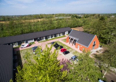 Locatie De Fender vanbovenaf gezien 2 lange grijze gebouwen en een rood gebouw