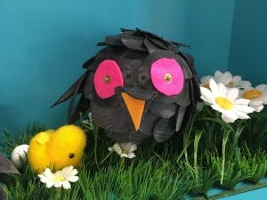 Zwarte bal met roze oogjes en witte madeliefjes eromheen